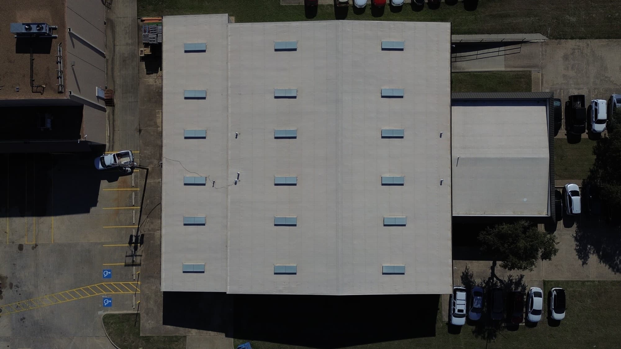 Drone overhead view of a large commercial building with uniform skylight grid